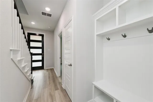 a view of a hallway with wooden floor and staircase