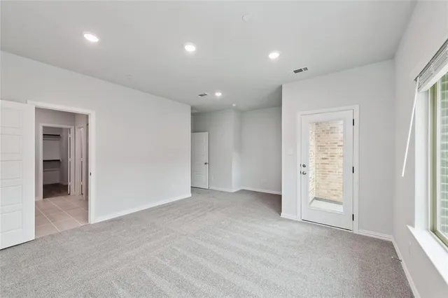 an empty room with closet and windows