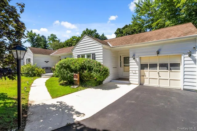 a view of a house with a yard and potted plants