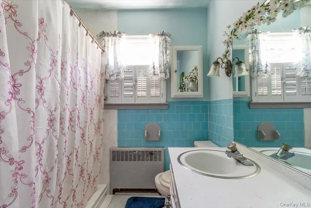 a bathroom with a sink a toilet and a window