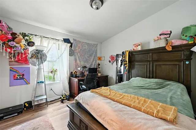 a bedroom with bed and wooden floor