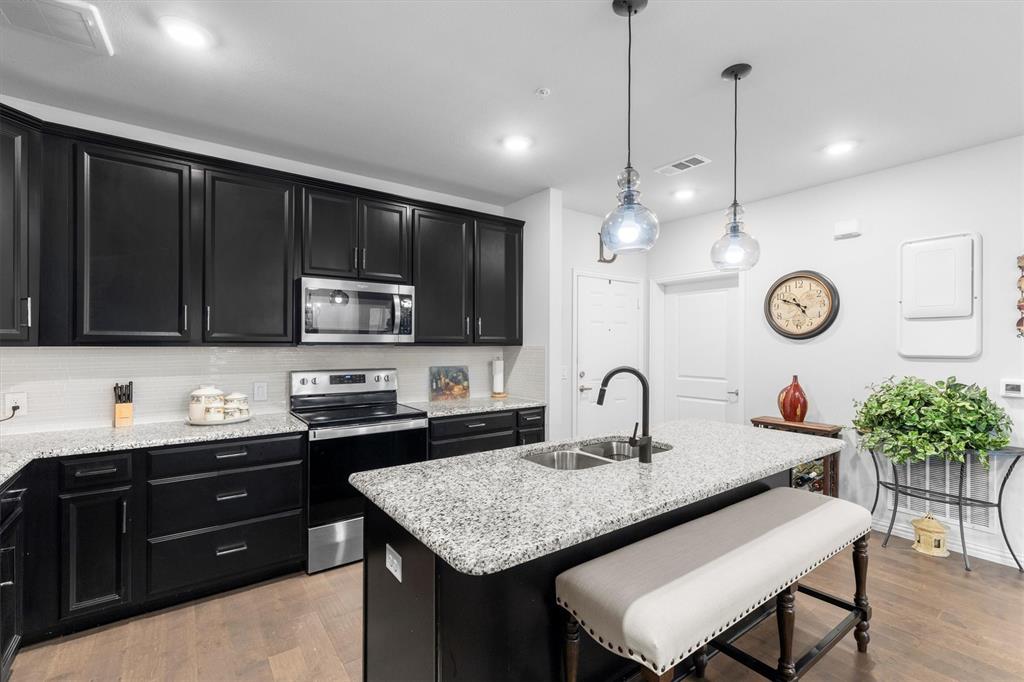 651 Watters Road, Unit 5205 Allen, TX 75013 - Photo 3 of 31 a kitchen with granite countertop a sink cabinets and stainless steel appliances