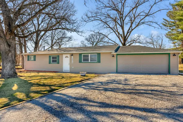 a backyard of a house with large trees and wooden fence