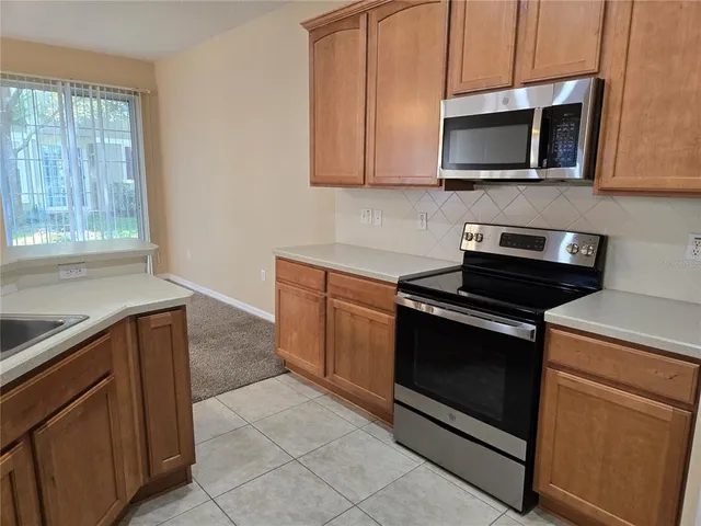 a kitchen with granite countertop cabinets stainless steel appliances and wooden cabinets