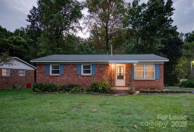 a view of a yard in front of a house with large trees