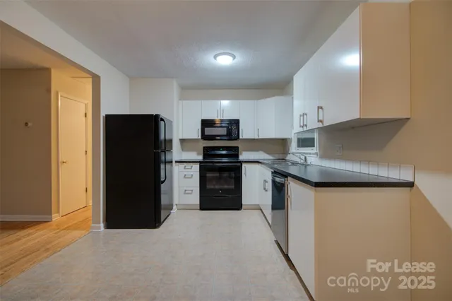 a kitchen with a refrigerator a microwave a sink and cabinets