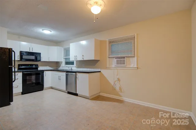 a kitchen with granite countertop a refrigerator stove top oven and sink