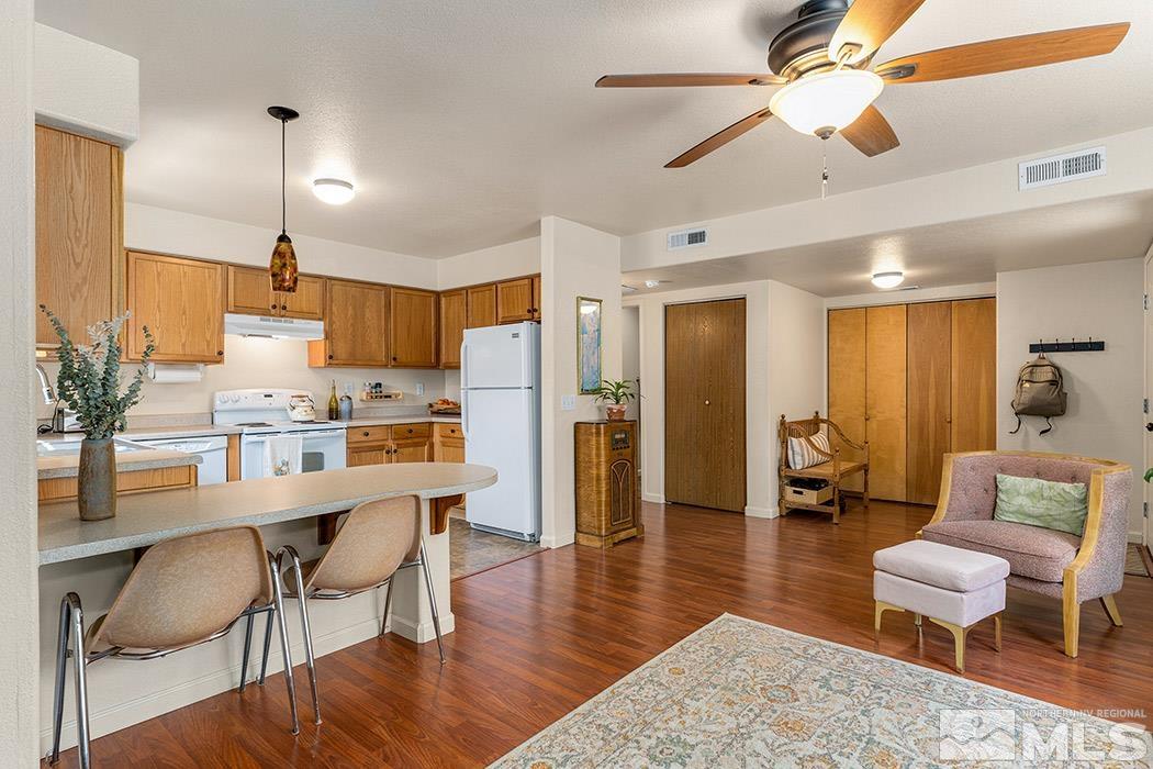 617 Elko Avenue Reno, NV 89512 - Photo 4 of 14 a kitchen with stainless steel appliances kitchen island granite countertop a refrigerator a stove a dining table and chairs with wooden floor