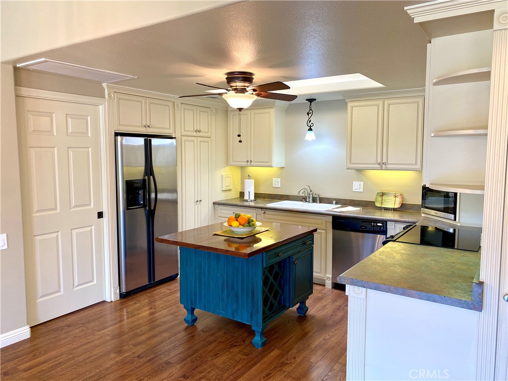 a kitchen with stainless steel appliances granite countertop wooden floors and sink