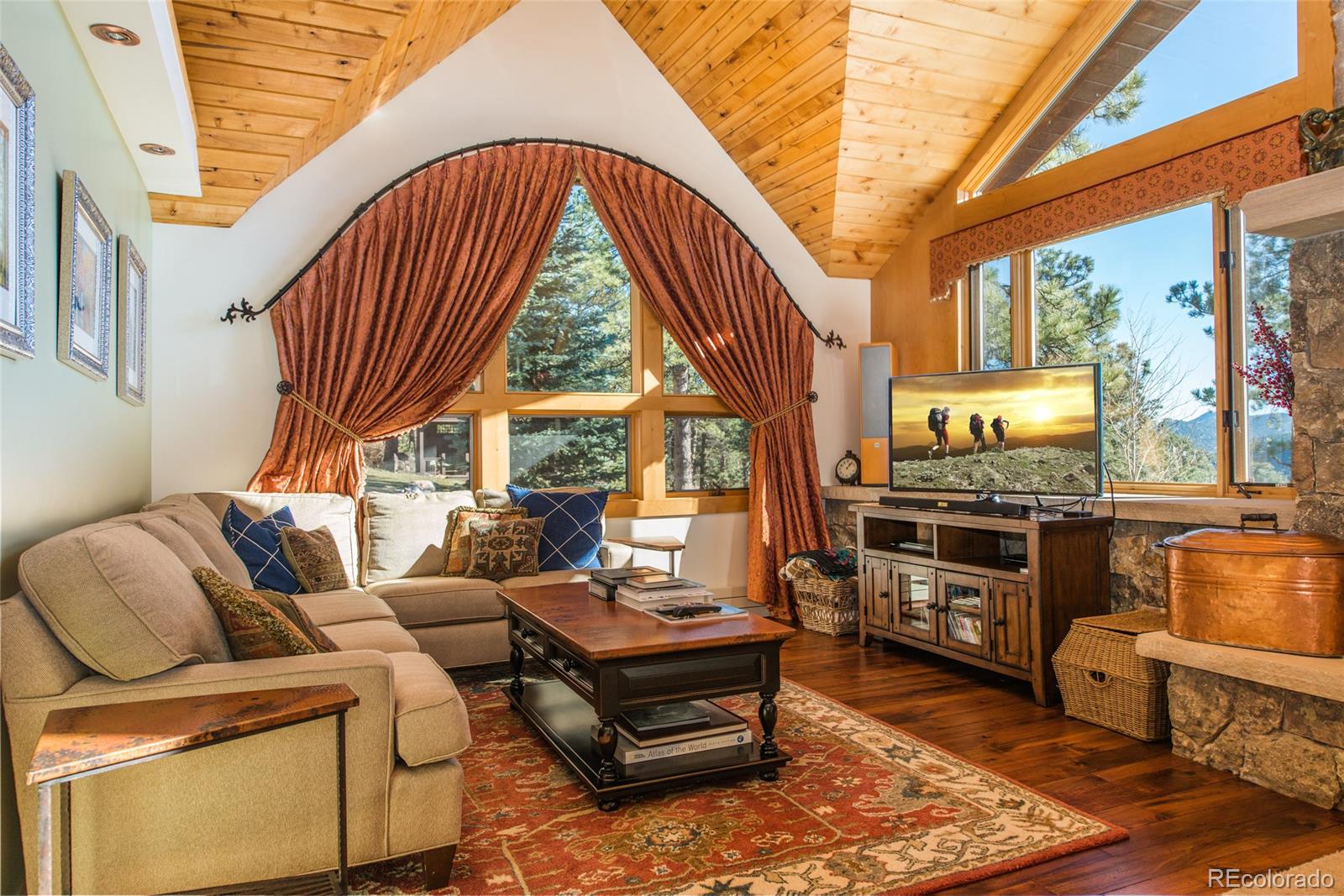 3731 Overlook Trail Evergreen, CO 80439 - Photo 5 of 35 a living room with furniture a flat screen tv and a floor to ceiling window