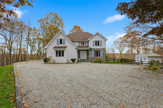 a view of a house with a yard and large tree