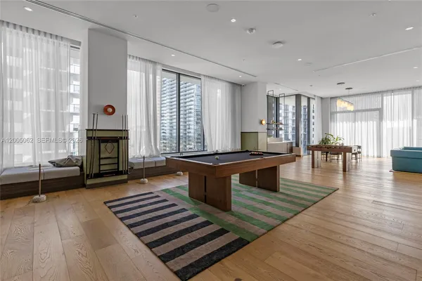 a large living room with stainless steel appliances granite countertop a couch a fireplace and a large window