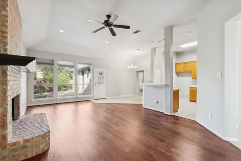 a view of an empty room with a fireplace and a window