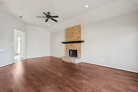 a view of empty room with wooden floor and fireplace