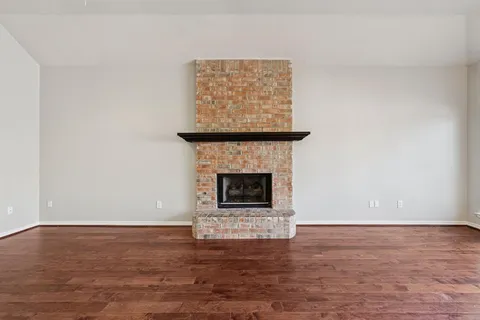 a living room with a fireplace and a wooden floor