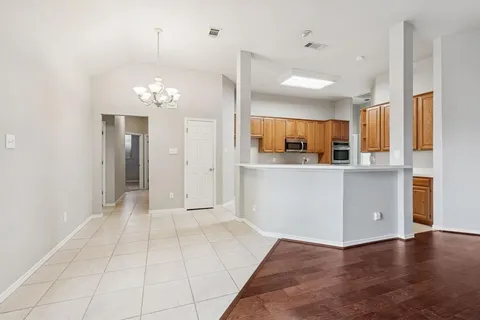 a view of a kitchen with a sink and chandelier