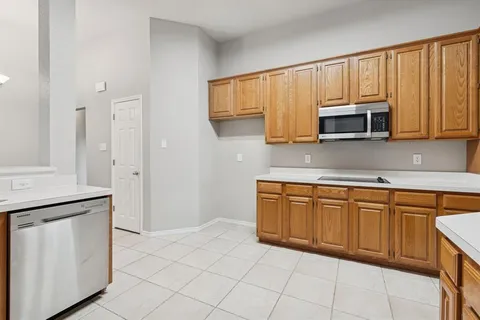 a kitchen with granite countertop a stove microwave and sink