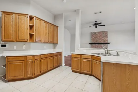 an empty room with wooden floor a fireplace and windows