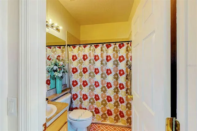 a white toilet sitting next to a shower curtain