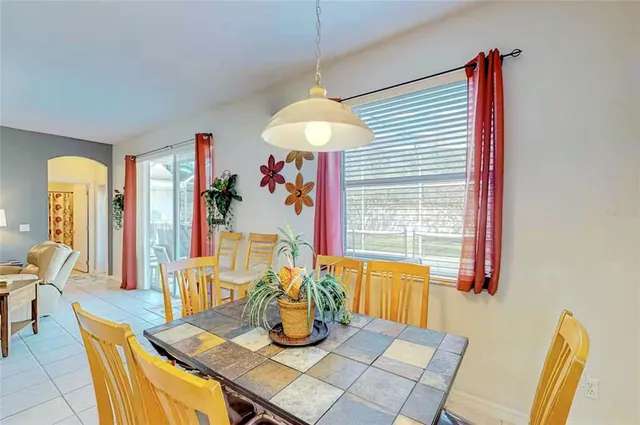 a dining room with wooden floor and a chandelier