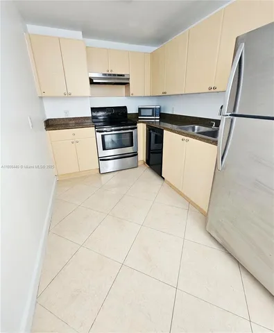 a kitchen with cabinets and steel appliances