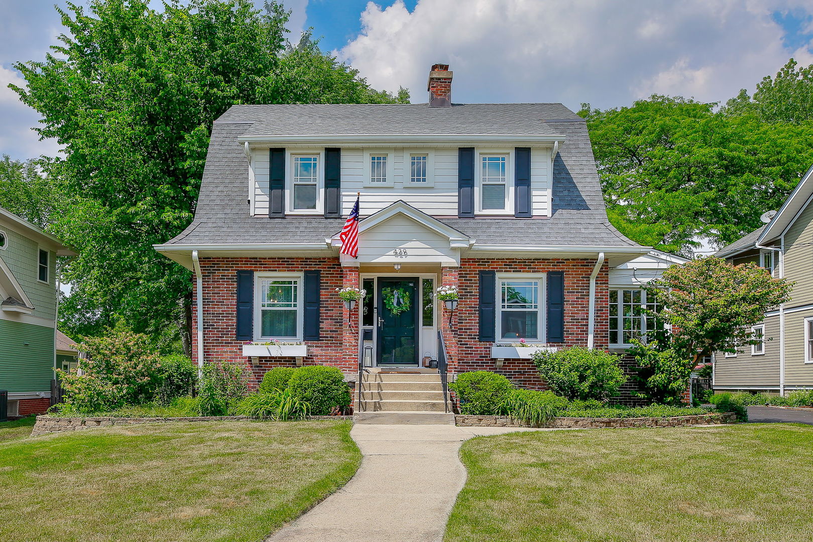a front view of a house with a garden