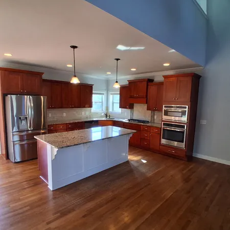 a kitchen with stainless steel appliances wooden floor sink stove and wooden floor