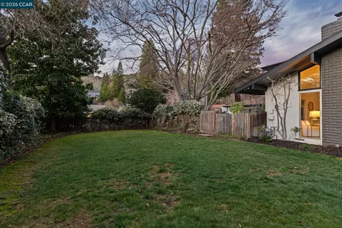 a view of a yard with wooden fence