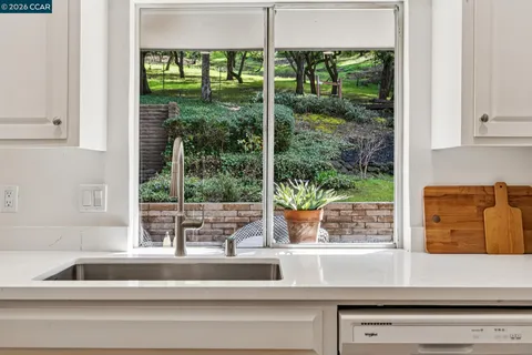a view of a sink with a dining table and chairs