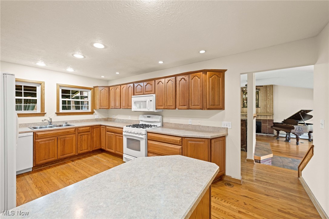 7590 Little Mountain Road Mentor, OH 44060 - Photo 12 of 40 Kitchen featuring a sink, light countertops, white appliances, light wood-style floors, and recessed lighting