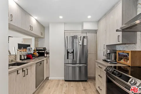 a kitchen with a sink stainless steel appliances and cabinets