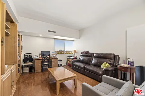 a living room with furniture and a dining table with wooden floor