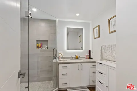 a bathroom with a double vanity sink a mirror and shower