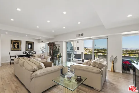 a living room with furniture and view of kitchen