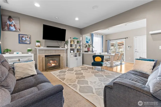 a living room with furniture a flat screen tv and a fireplace