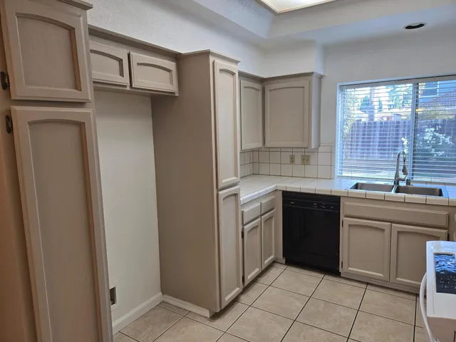 a kitchen with stainless steel appliances granite countertop a sink and dishwasher a refrigerator with wooden cabinets