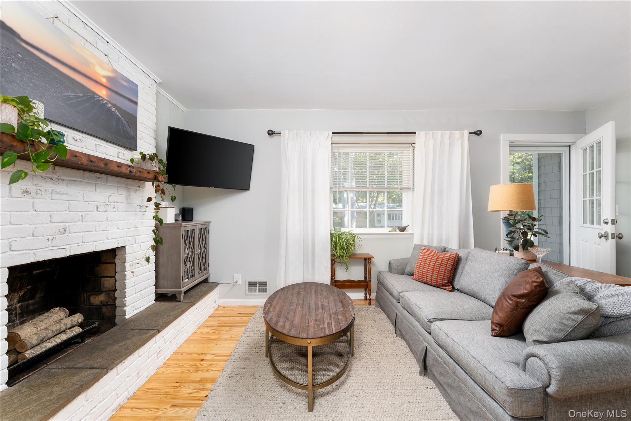 8 Foxboro Road Hampton Bays, NY 11946 - Photo 13 of 50 a living room with furniture a flat screen tv and a fireplace