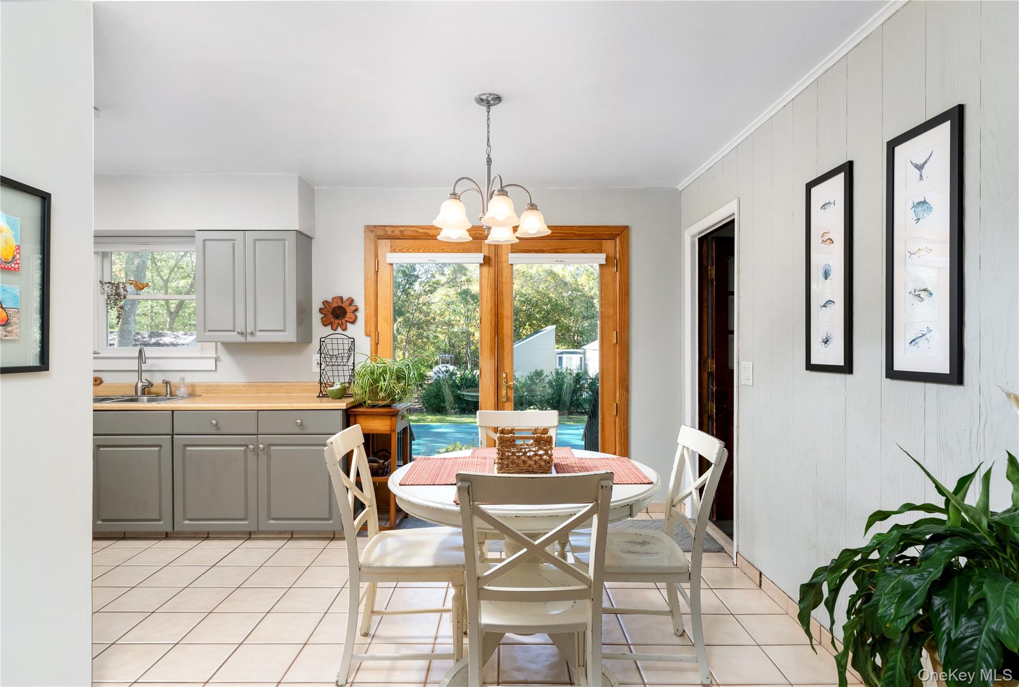 8 Foxboro Road Hampton Bays, NY 11946 - Photo 15 of 50 a dining room filled a chandelier and kitchen view