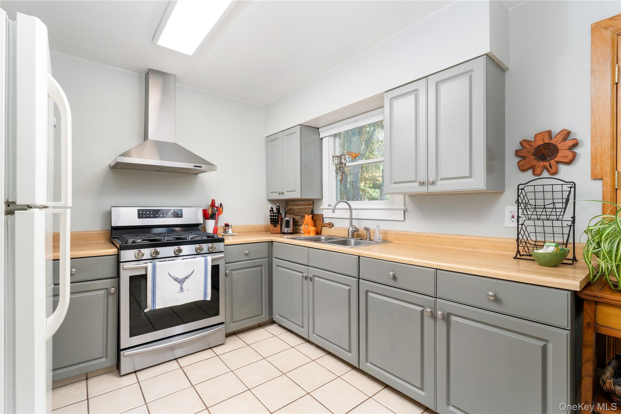 8 Foxboro Road Hampton Bays, NY 11946 - Photo 16 of 50 a kitchen with stainless steel appliances granite countertop a stove a sink and a refrigerator