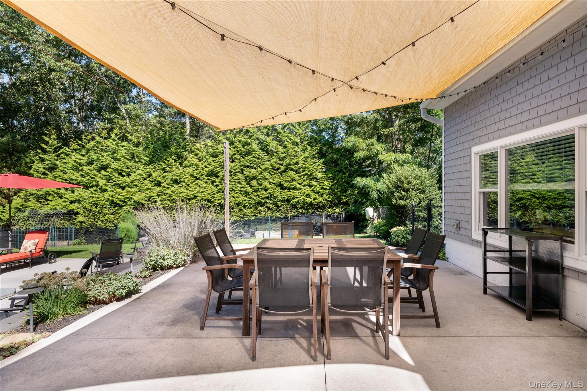 8 Foxboro Road Hampton Bays, NY 11946 - Photo 34 of 50 a view of a patio with a table and chairs and potted plants