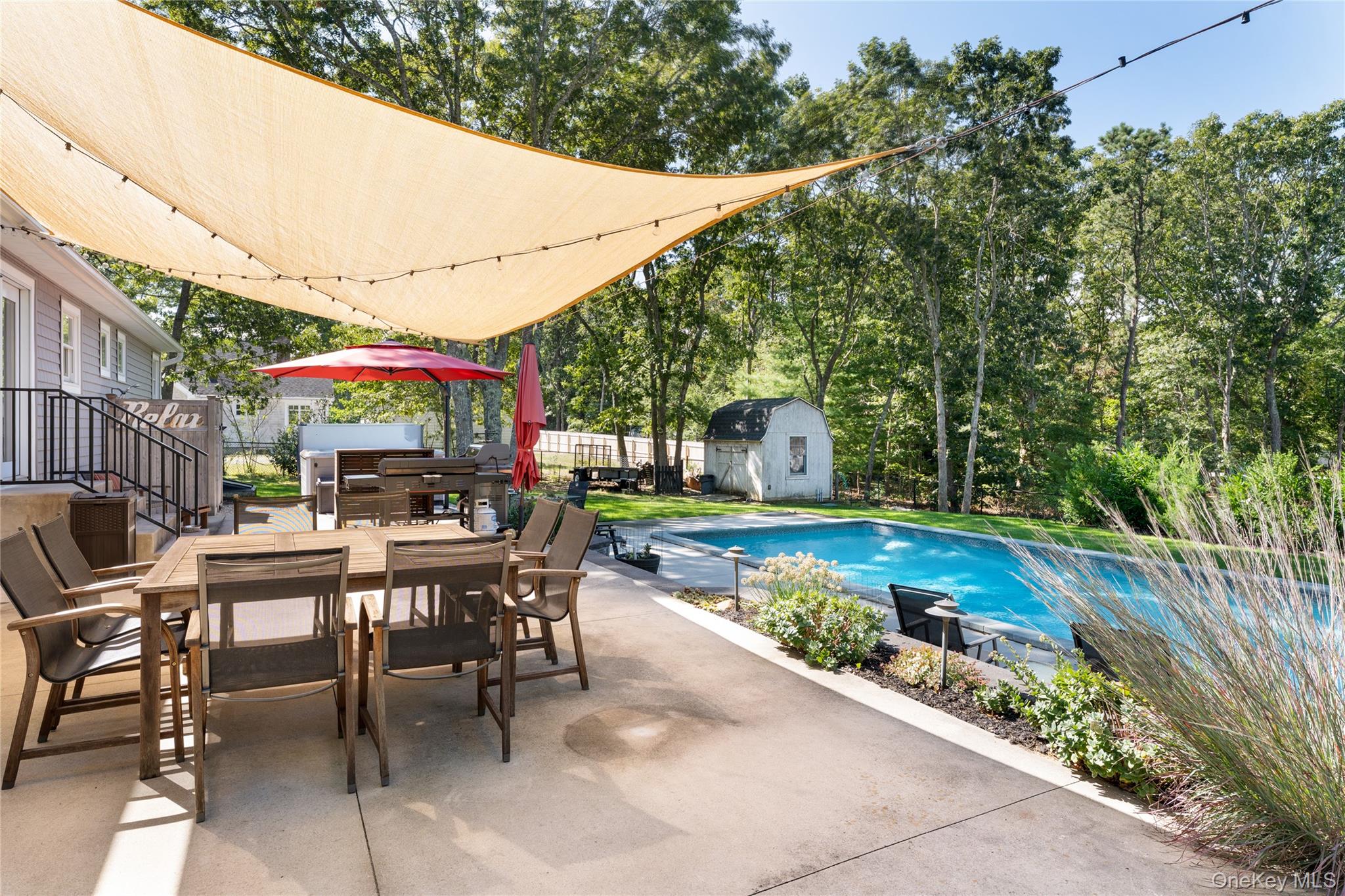 8 Foxboro Road Hampton Bays, NY 11946 - Photo 39 of 50 a patio with wooden table and chairs