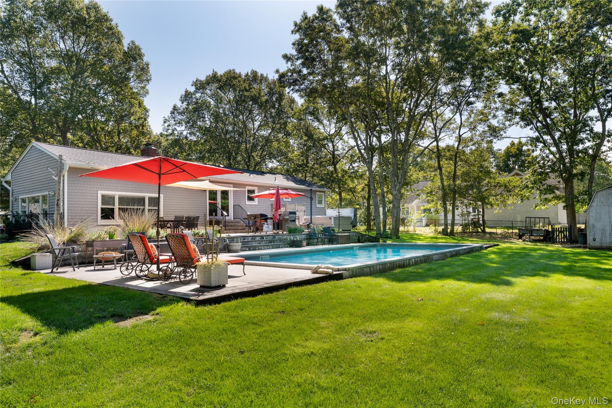 8 Foxboro Road Hampton Bays, NY 11946 - Photo 5 of 50 a view of swimming pool with lawn chairs and large trees
