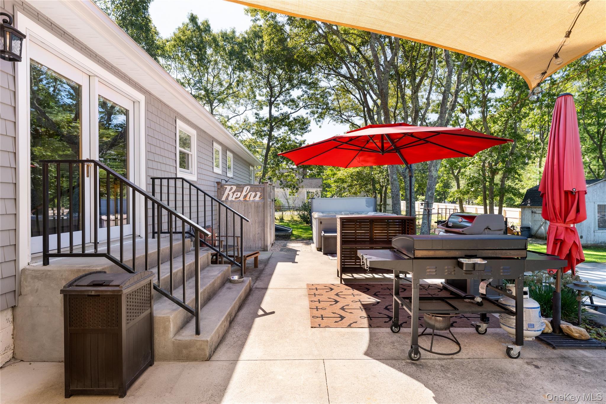 8 Foxboro Road Hampton Bays, NY 11946 - Photo 8 of 50 a view of a patio with a table and chairs under an umbrella