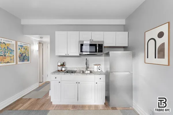 a kitchen with stainless steel appliances granite countertop a refrigerator sink and stove