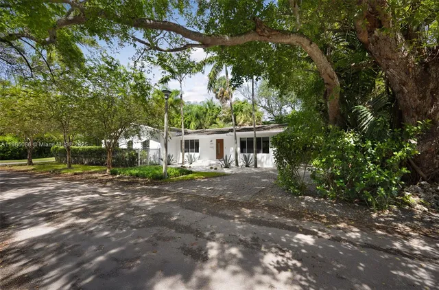 a front view of a house with a yard and trees