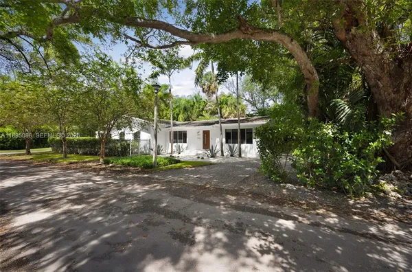 a front view of a house with a yard and trees