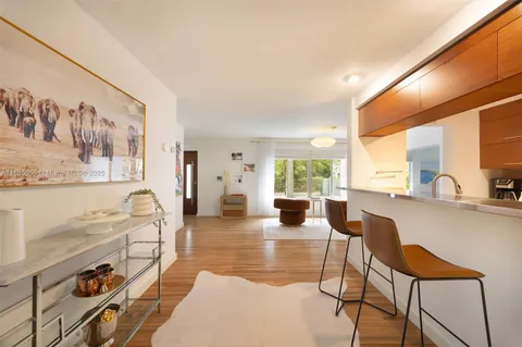 a living room with furniture a large window with kitchen view