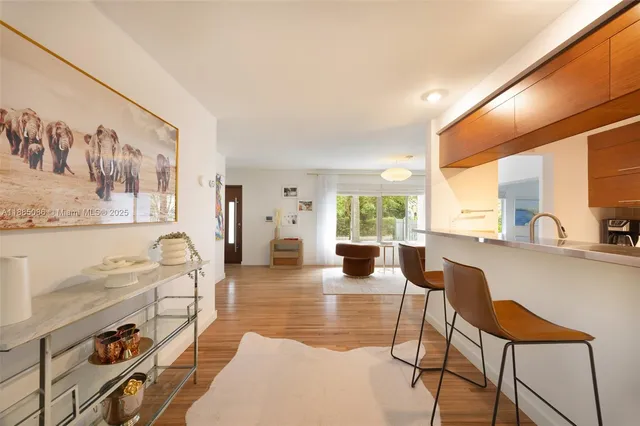 a living room with furniture a large window with kitchen view