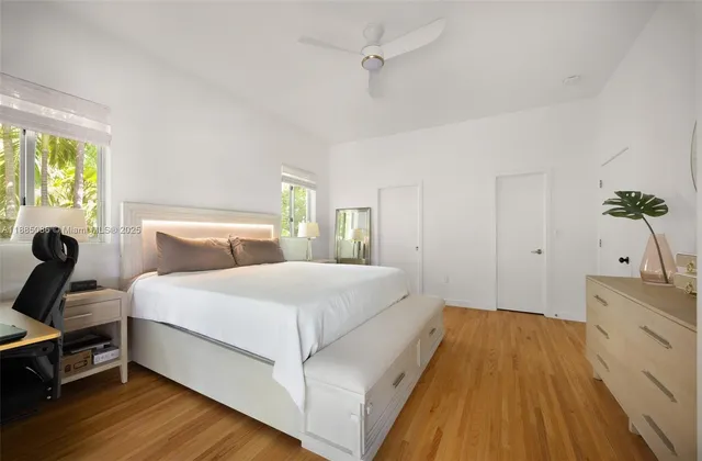 a bedroom with a bed and a potted plant on dresser