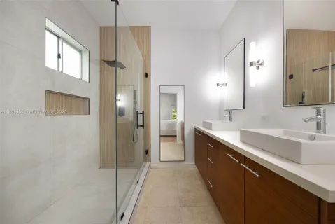 a large bathroom with a double vanity sink a mirror and a shower